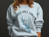 Light blue sweatshirt with Clarks Hill Lake Georgia map and compass graphic.