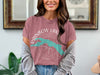 Pink t-shirt with "RAINBOW LAKE MAINE" text and teal lake graphic on compass rose.