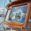 Turquoise Pomme de Terre Life sticker on a wooden boat window.