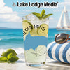Glass with drink, limes, mint, and sunglasses on a striped pillow at the beach.