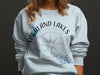 Light blue sweatshirt with "Highland Lakes Texas" and compass graphic.