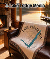 Fringed blanket with Lake Vermillion map and compass design on a couch.