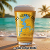 Glass of beer with "The Grassy Lake" text and map graphic on beach.