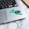 Turquoise Clearwater Life sticker with black text placed on a laptop keyboard.