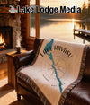 Woven blanket with Lake Havasu map and compass design on a leather couch.