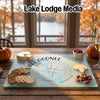 Tempered glass cutting board featuring a Lake Oconee map and compass design on a wooden table.