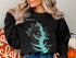 Black sweatshirt with a teal lake outline and compass graphic, "Lake Conroe Texas" text.