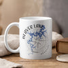 White mug with Beaver Lake map and compass design, steam rising.
