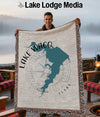 Man holding a woven blanket featuring the shape of Lake Waco, Texas, and a compass rose.