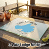 A glass cutting board featuring a map of Lake Mendota, Wisconsin, on a wooden outdoor bar.