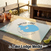 Glass cutting board featuring a map of Mono Lake California rests on an outdoor wooden table.