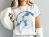 White t-shirt with blue Little Saint Germain Lake map and compass design.