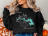 Black sweatshirt with "Beautiful Potato Lake South Dakota" map and compass design.