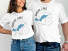 White t-shirts with Shoal Lake, Ontario map and compass design.
