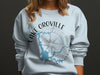 Light blue sweatshirt with Lake Oroville California design and compass graphic.