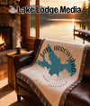 Blanket with Lake Arrowhead, California map and compass, on a leather couch.
