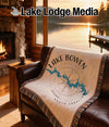 Tapestry blanket with Lake Bowen South Carolina map and compass rose on leather couch.