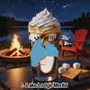 Glass with layered drink, campfire, red chair, and s'mores ingredients at night.
