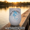 A white insulated wine tumbler with a Lake Blue Ridge map design sits on a wooden dock at sunset.