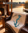 Throw blanket with Perry Lake, Kansas map and compass design on a couch.