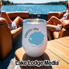 A white Crater Lake Oregon wine tumbler sits on a boat table with two women relaxing in the background.