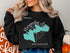 Black sweatshirt with turquoise Merrymeeting Lake New Hampshire map graphic.