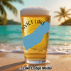 Glass of beer with "Convict Lake" text on a beach background.