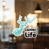 Lanier Life sticker with turquoise lake shape on glass, blurred background.