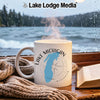 White mug with "Lake Michigan" and compass design on a rainy window ledge.