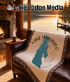 Woven throw blanket with Lake Wanahoo Nebraska design on a couch.