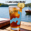Glass of iced tea with blue New York map overlay and lemon slice, "Lake Lodge Media" logo.