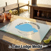 A glass cutting board with a blue map of Lake Pontchartrain sits on a wooden dock.