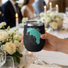 Black tumbler with Garibaldi Lake map and compass graphic, held at a table setting.