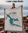 Hebgen Lake Montana map design on a fringed throw blanket held by a man.