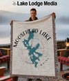 Man holds a Moosehead Lake, Maine woven blanket with a map design.