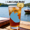 Iced tea in a glass with a lemon slice, beside a book on a wooden table.