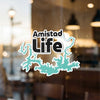 Amistad Life logo with turquoise lake outline and Lake Lodge Media LLC.