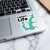 Sticker with "Lavon Life" text and a teal lake silhouette on a laptop keyboard.