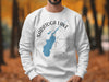 White sweatshirt with Saratoga Lake map and compass graphic.