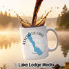 White mug with Keechelus Lake design and compass, coffee splash.