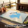 Customized glass cutting board featuring a map of Big Lake, Arizona, resting on an outdoor wooden table.