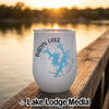 A white insulated wine tumbler with Badin Lake North Carolina graphics sits on a wooden dock.