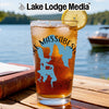 Glass of iced tea with lake graphic, lemon slice, and boat in background.