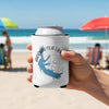 White can koozie with Arkabutla Lake Mississippi map and compass design held on a beach.