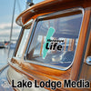 Honeoye Life sticker on a wooden boat window, Lake Lodge Media logo below.
