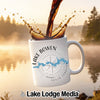 White mug with "Lake Bowen South Carolina" and compass design, with coffee splashing.