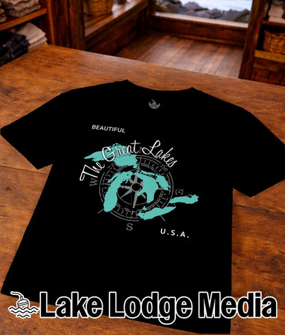 Black t-shirt with "The Great Lakes" compass graphic and "Lake Lodge Media" text.