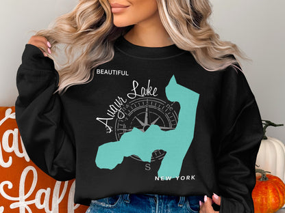 Black sweatshirt featuring a turquoise outline of a lake with a compass and "Beautiful Lake New York".