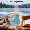 White mug with "Emerald Lake Canada" map design on a table by a window.