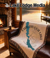 Chautauqua Lake New York map on blanket draped on leather couch with lake view.